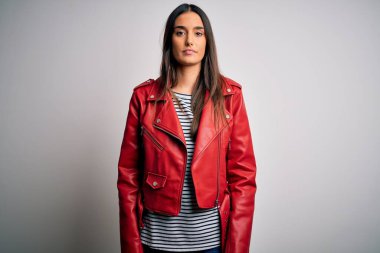 Genç, güzel, esmer bir kadın, sıradan çizgili tişört ve yüzünde ciddi bir ifade olan kırmızı bir ceket giyiyor. Basit ve doğal bir şekilde kameraya bakıyorsun..
