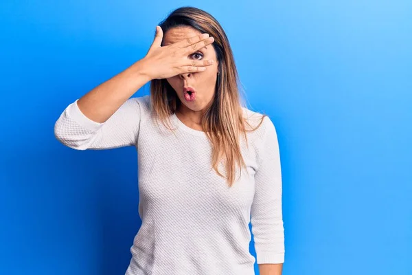 Jovem Mulher Bonita Vestindo Camiseta Casual Espreitando Choque Cobrindo Rosto — Fotografia de Stock