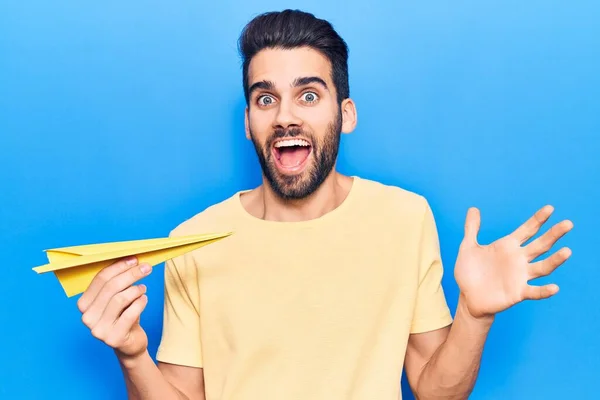 Jovem Homem Bonito Com Barba Segurando Avião Papel Amarelo Celebrando — Fotografia de Stock