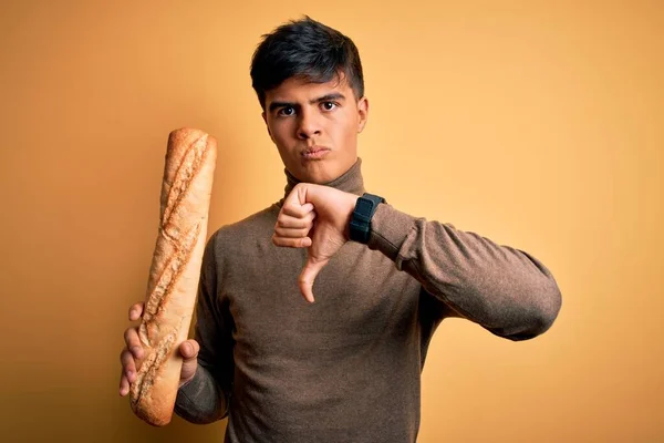 Young Handsome Man Holding Homemade Fresh Bread Isolated Yellow Background — Stock Photo, Image