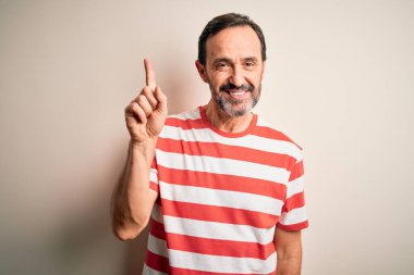 Orta yaşlı, beyaz çizgili tişört giyen, izole edilmiş beyaz arka planda duran, kendine güvenen ve mutlu bir şekilde gülümseyen orta yaşlı bir adam..