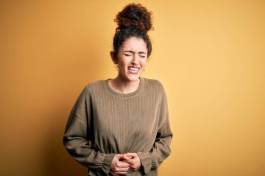 Kıvırcık saçlı ve piercingli genç ve güzel bir kadın. Midesi bulanan, acı verici bir hastalık yüzünden eli karnında sıradan bir elbise giyiyor. Ache kavramı.