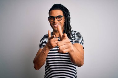 Çizgili tişört giyen ve gözlüklü, mutlu ve komik yüzlü parmaklarını kameraya gösteren Afro-Amerikan genç adam. İyi enerji ve titreşimler.