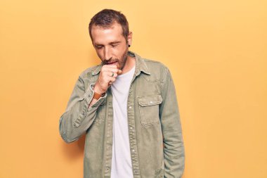 Sıradan kıyafetler giyen genç yakışıklı adam kendini iyi hissetmiyor ve soğuk algınlığı veya bronşitin belirtisi olarak öksürüyor. sağlık hizmeti kavramı. 