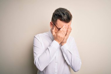 Gözlük takan genç yakışıklı iş adamları ve izole edilmiş arka plan üzerinde zarif gömlekler ve ağlarken suratını ellerle kapatan üzgün bir ifade. Depresyon kavramı.