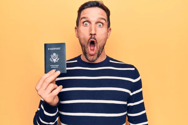 Młody Przystojny Turysta Trzyma Paszport Stanów Zjednoczonych Nad Odizolowanym Żółtym — Zdjęcie stockowe