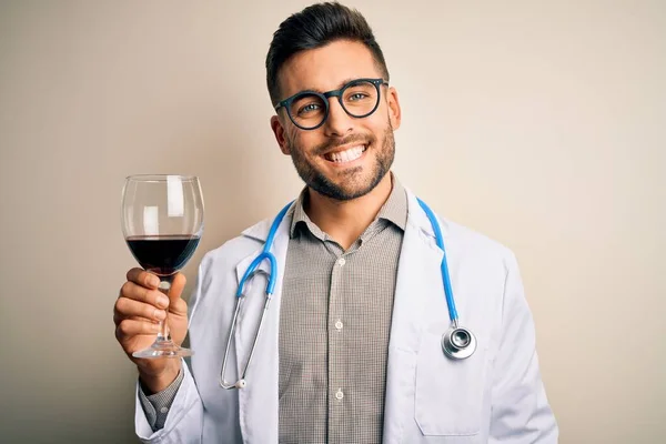 Młody Lekarz Noszący Stetoskop Pijący Kieliszek Świeżego Wina Odosobnionym Tle — Zdjęcie stockowe