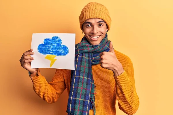 Young african amercian man holding thunder draw smiling happy and positive, thumb up doing excellent and approval sign