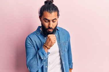 Gündelik kıyafetler giyen genç bir Arap kendini iyi hissetmiyor ve soğuk algınlığı veya bronşitin belirtisi olarak öksürüyor. sağlık hizmeti kavramı. 