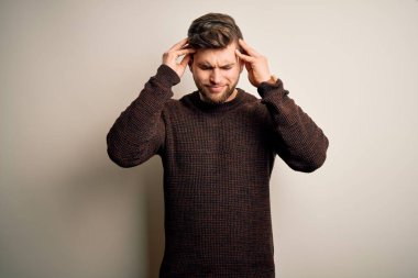 Sakallı ve mavi gözlü genç, yakışıklı, sıradan bir süveter giyen, baş ağrısı çeken çaresiz ve stresli bir adam. Çünkü acı ve migren. Ellerini başının üstüne koy..