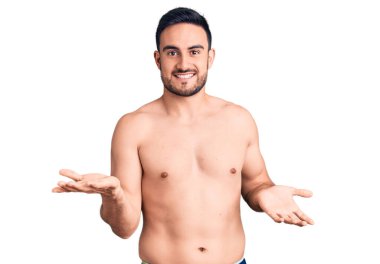 Mayo giyen genç yakışıklı adam gülümsüyor. Kollarını açıp gülümsüyor. Hoş geldin, olumlu ve kendinden emin selamlar. 