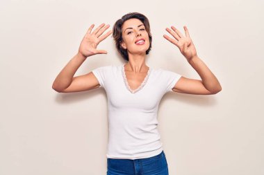 Gündelik giysiler giyen genç ve güzel bir kadın dokuz numarayı gösterip işaret ederken kendine güvenen ve mutlu bir şekilde gülümsüyor.. 