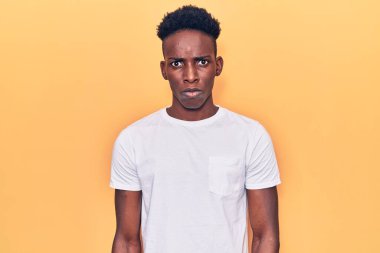 Gündelik kıyafetler giyen, kuşkucu ve gergin, sorun yüzünden surat asan genç Afro-Amerikan. negatif kişi. 