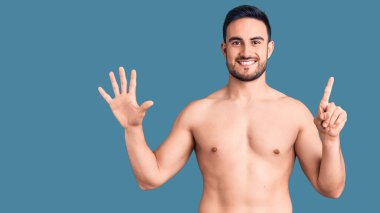 Mayo giyen genç ve yakışıklı bir adam altı numarayı gösterip işaret ederken kendinden emin ve mutlu bir şekilde gülümsüyor.. 