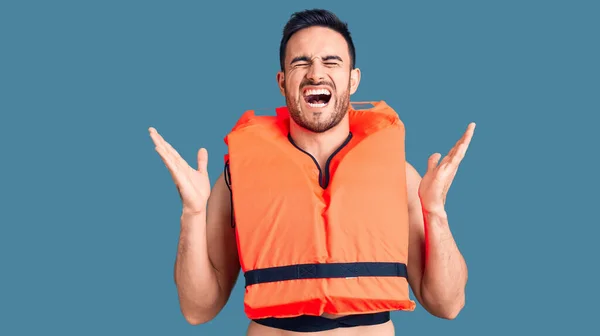 Young Handsome Man Wearing Lifejacket Celebrating Mad Crazy Success Arms — Stock Photo, Image