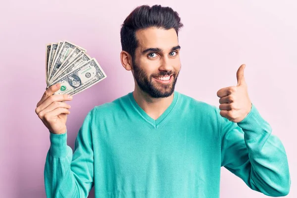 Joven Hombre Guapo Con Barba Sosteniendo Montón Dólares Sonriendo Feliz —  Fotos de Stock