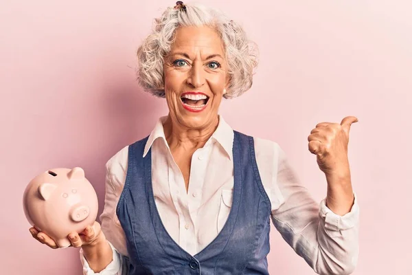 Senior Gråhårig Kvinna Håller Spargris Bank Pekar Tummen Upp Till — Stockfoto