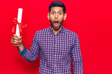 Diploma almış genç bir latin adam. Korkmuş ve ağzı açık kalmış, şaşırmış ve şaşırmış. 