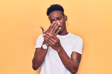 Genç Afro-Amerikan adam günlük kıyafetler giyiyor. Ellerinde ve parmaklarında ağrı var. Eklem iltihabı. 