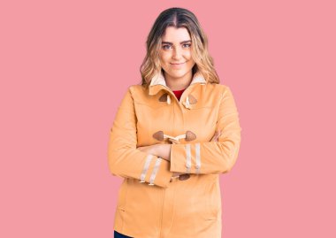 Sıradan kıyafetler giyen, kollarını kavuşturup kameraya gülümseyen beyaz bir kadın. pozitif kişi. 