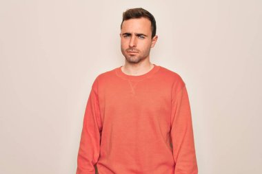 Mavi gözlü, sıradan bir süveter giyen, beyaz arka planda duran, şüpheci ve gergin, sorun yüzünden somurtan genç, yakışıklı bir adam. Negatif kişi.