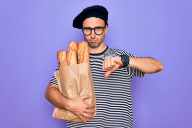 Mavi gözlü genç fırıncı. Fransız beresi takıyor. Elinde kızgın yüzlü ekmek çantası var. Negatif işareti var.