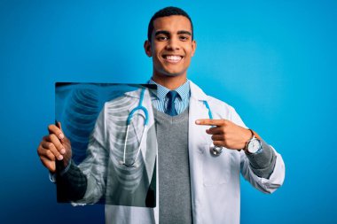 Steteskop takan yakışıklı Afro-Amerikan doktor. Göğüs röntgeni çekerken çok mutlu.