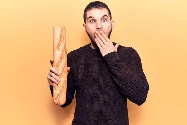 Young Handsome Man Holding Baguette Covering Mouth Hand Shocked Afraid — Stock Photo, Image