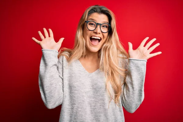 Genç, sarışın, süveter ve gözlük takan genç bir kadın çılgın ve başarıyı kollarını kaldırıp heyecanla haykırarak kutluyor. Kazanan konsept