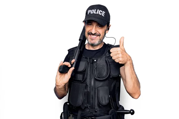 中世のハンサムな警官を着て警察制服と防弾ベストを保持散弾銃笑顔と正 親指アップ行う優れた承認サイン — ストック写真