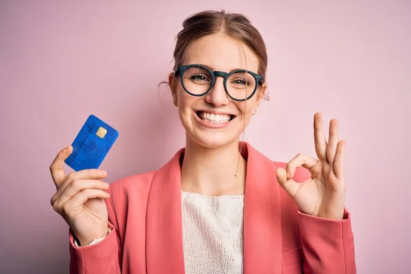Young Beautiful Redhead Woman Holding Credit Card Isolated Pink Background — Stock Photo, Image