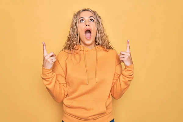 Junge Schöne Blonde Sportliche Frau Lässigem Sweatshirt Vor Gelbem Hintergrund — Stockfoto