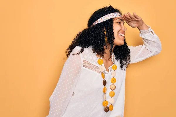 サングラスとヴィンテージアクセサリーを身に着けている若いアフリカ系アメリカ人の巻きヒッピー女性は 頭の上に手で遠くを見て非常に幸せと笑顔 検索の概念 — ストック写真