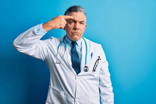 Średnim Wieku Przystojny Siwowłosy Lekarz Noszący Płaszcz Niebieski Stetoskop Wskazujący — Zdjęcie stockowe