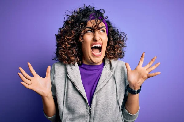 漂亮的卷曲的Arab女运动员穿着紫色背景的运动服 疯狂地大喊大叫 带着咄咄逼人的表情和手臂 沮丧的概念 — 图库照片