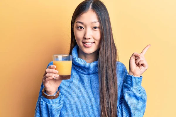 Νεαρή Όμορφη Κινέζα Γυναίκα Πίνει Ένα Ποτήρι Χυμό Πορτοκαλιού Χαμογελώντας — Φωτογραφία Αρχείου