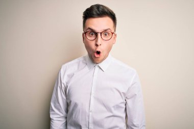 Genç yakışıklı iş adamları gözlük takıyor ve zarif gömlekler giyip izole edilmiş arka planda korku, korku ve heyecan dolu bir yüz ifadesiyle dehşete düşmüş ve şok olmuştu..