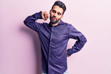 Sakallı, sıradan gömlekli, yorgun ve rahat, uykulu ve sabahın erken saatlerinde esneyen genç bir adam. 