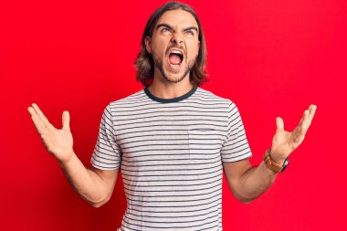 Genç, yakışıklı, sıradan kıyafetler giyen çılgın ve deli gibi bağıran agresif bir ifade ve kollarla bağıran bir adam. hüsran kavramı. 