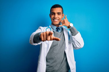 Yakışıklı Afro-Amerikan doktor ceketli ve steteskop takmış mavi arka planda gülümseyen telefonda konuşarak seni işaret ediyor. Ara beni..
