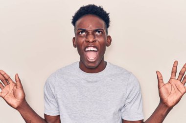 Genç, Afro-Amerikalı, günlük kıyafetler giymiş çılgın ve kızgın bir şekilde bağırıyor, agresif bir ifade ve kollarla bağırıyor. hüsran kavramı. 