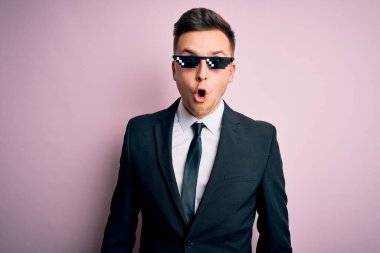 Genç, beyaz, beyaz, komik, cani gözlüklü bir iş adamı. Şaşırtıcı bir ifade, korku ve heyecan dolu bir yüz..