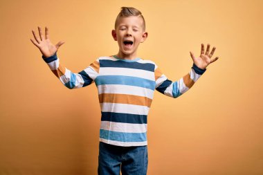 Sarı arka planda mavi çizgili tişört giyen, mavi gözlü küçük beyaz çocuk kollarını kaldırmış ve kapalı gözlerle heyecanla haykırarak başarıyı kutluyor. Kazanan konsept