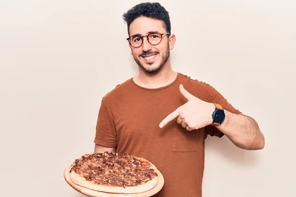 Молодий Іспаномовний Чоловік Окулярах Тримає Італійську Піцу Посміхаючись Щасливим Вказуючи — стокове фото
