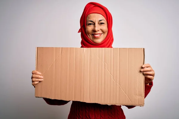 中年黑发女子 身穿传统的穆斯林头巾 高举着幸福的旗帜 站在那里 带着自信的微笑 露出牙齿 — 图库照片