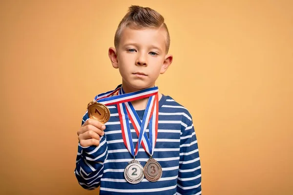 Küçük Beyaz Çocuk Ödül Yarışması Madalyalarını Sarı Arka Planda Takıyor — Stok fotoğraf