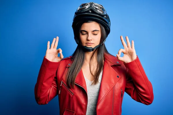 若い美しいブルネットのオートバイのヘルメットとジャケットを身に着けている女性は 指で瞑想のジェスチャーをして閉じ目でリラックスして笑顔 ヨガのコンセプト — ストック写真