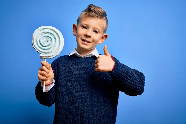 Young Little Caucasian Kid Eating Sweet Candy Lollipop Blue Isolated — Stock Photo, Image