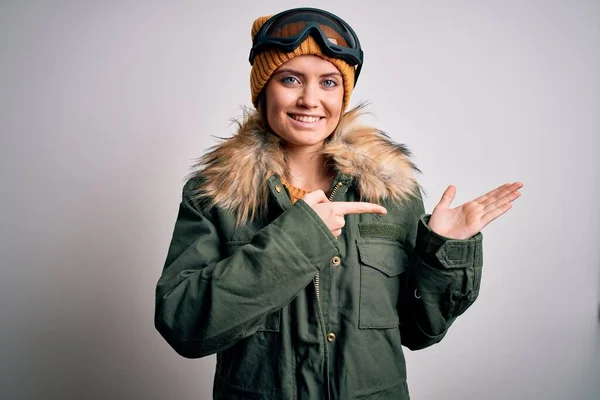 年轻美丽的滑雪者 蓝眼睛 身穿雪地运动服 戴着滑雪板护目镜 手牵着手 指指点点着镜头 惊讶地微笑着 — 图库照片
