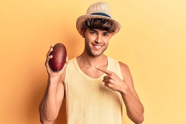 Hombre Hispano Joven Que Lleva Sombrero Sosteniendo Mango Sonriendo Feliz — Foto de Stock